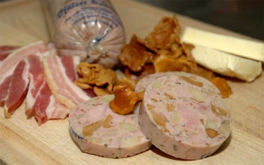 Pfälzer Saumagen verfeinert mit Pfifferlingen, Speck und Butter.